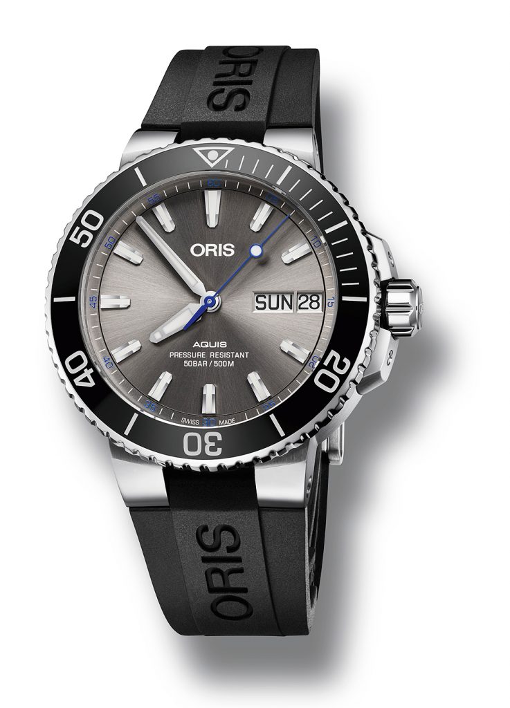 Ocean-blue elements, like the central seconds hand and minute scale numerals, highlight the gray dial.